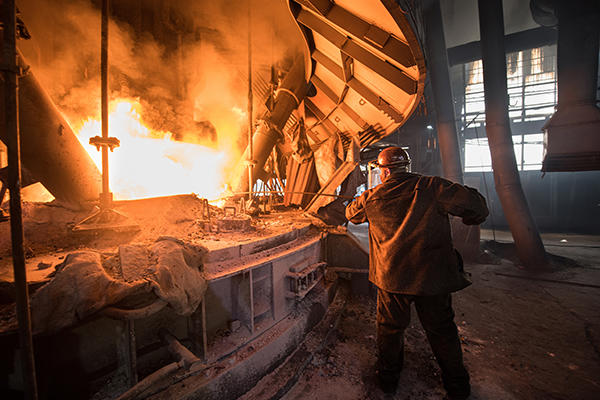 Stahlarbeiter bei der Arbeit in der Nähe des Lichtbogenofens